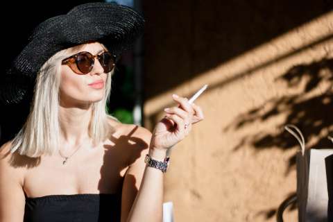タバコを吸いながらにやける白人女性